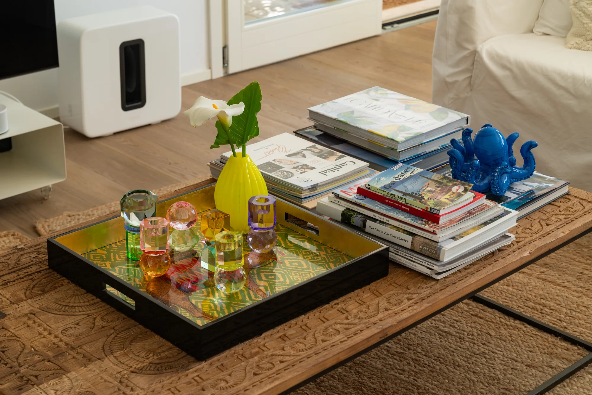 Coffee table with design books, a lacquered tray and colorful glass objects