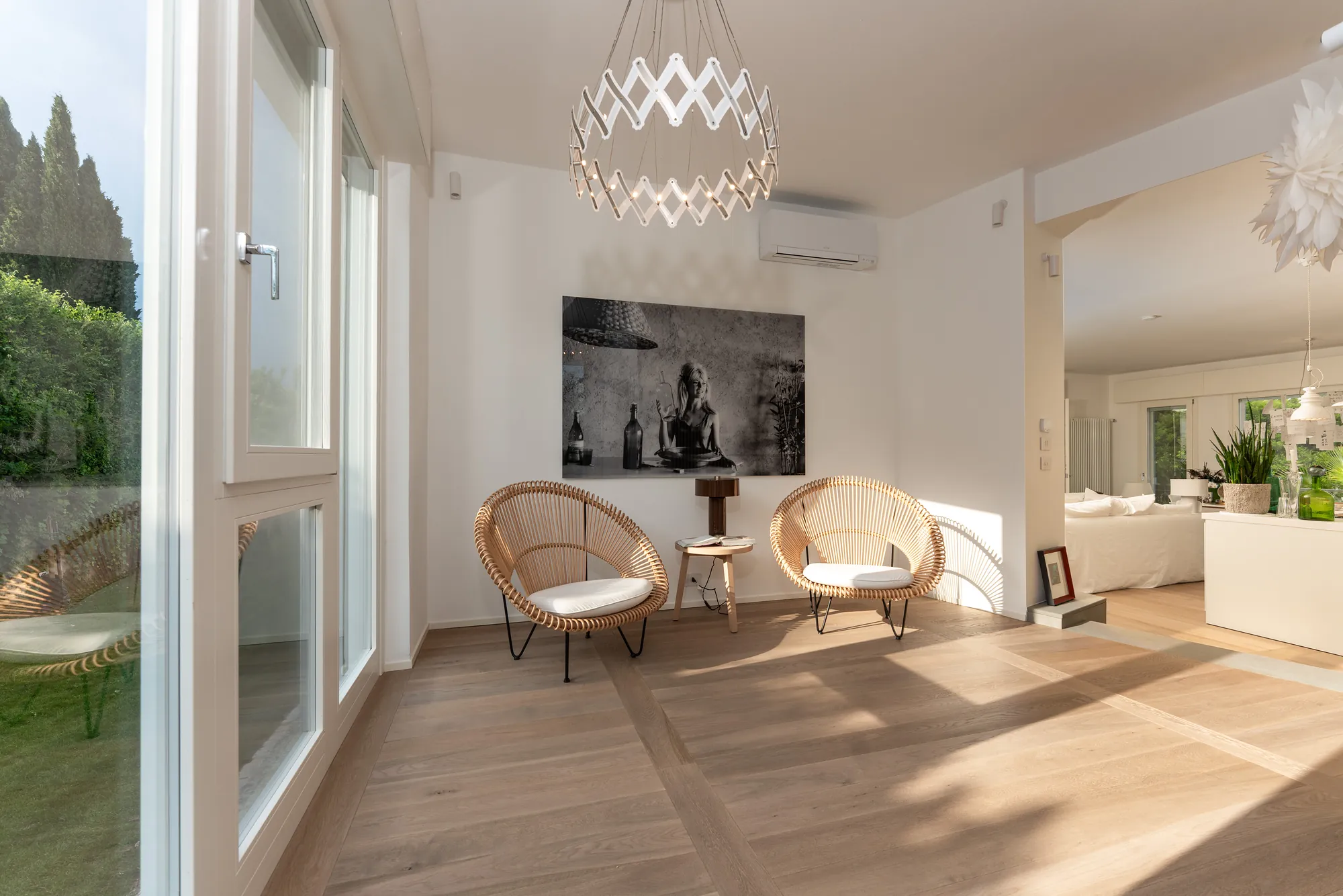 Entrance hall with rattan chairs, a black-and-white photograph and oak parquet