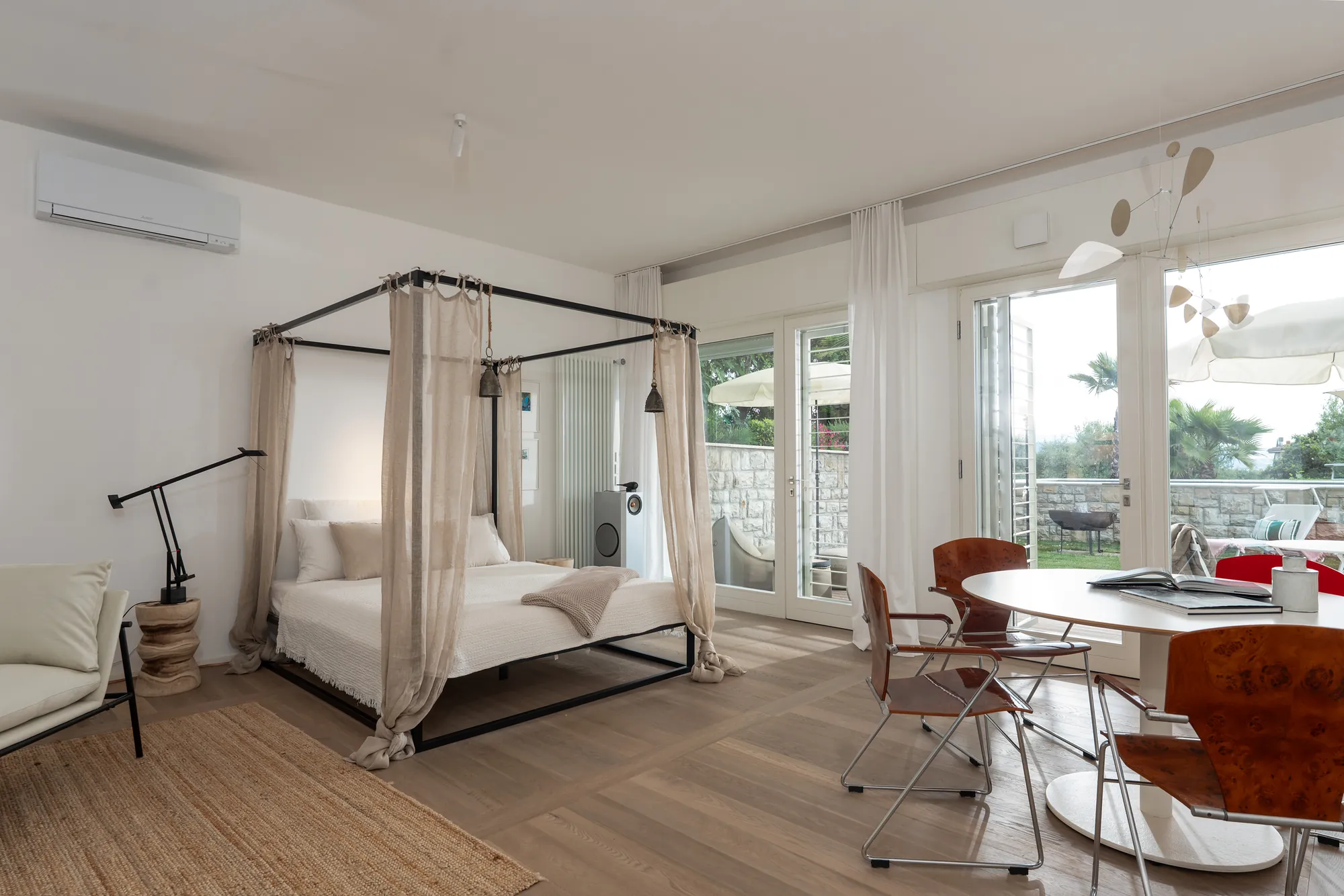 The 60 m² garden apartment with four-poster bed, round table and doors to the terrace