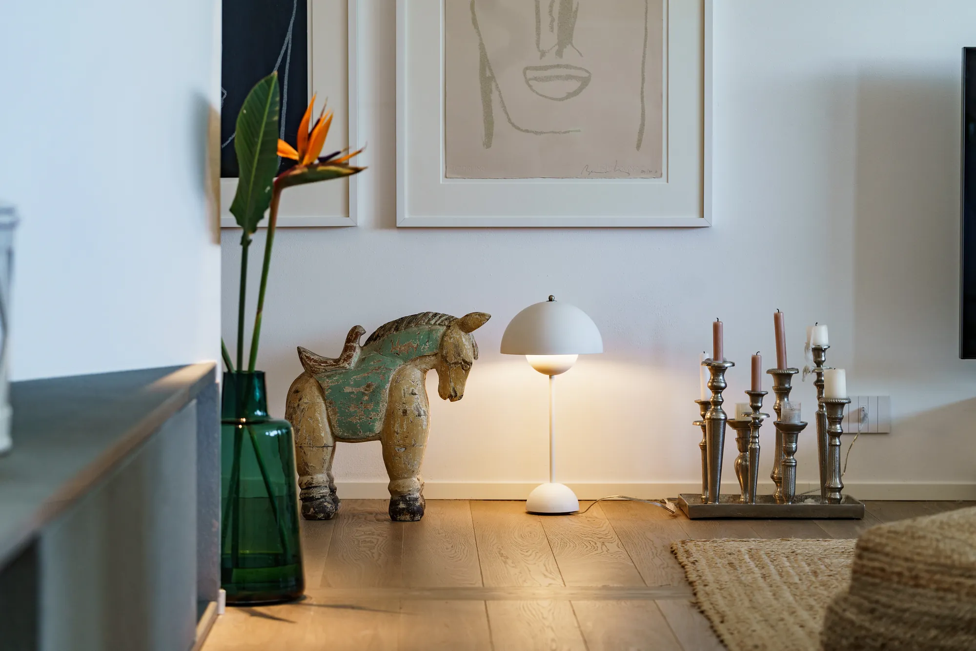 Interior detail with a carved horse, a mushroom lamp and bird of paradise flowers
