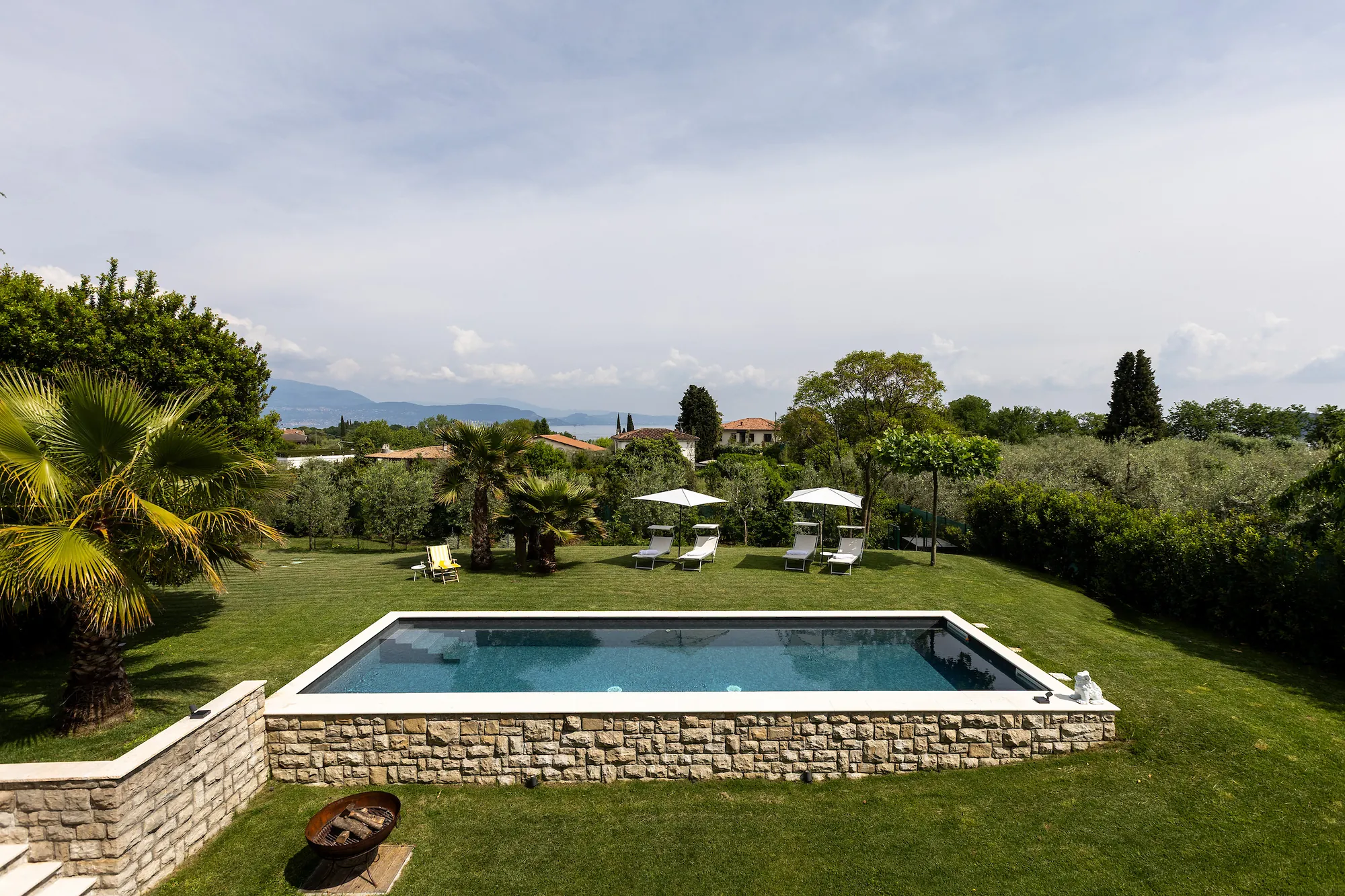 View from the terrace down to the pool, the garden and the hills on the horizon