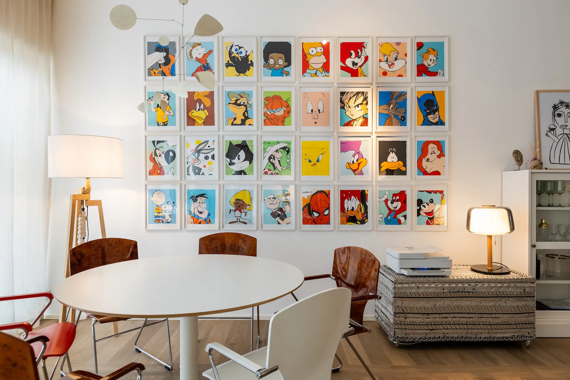 Dining corner with a round white table, leather chairs and a pop-art comic wall
