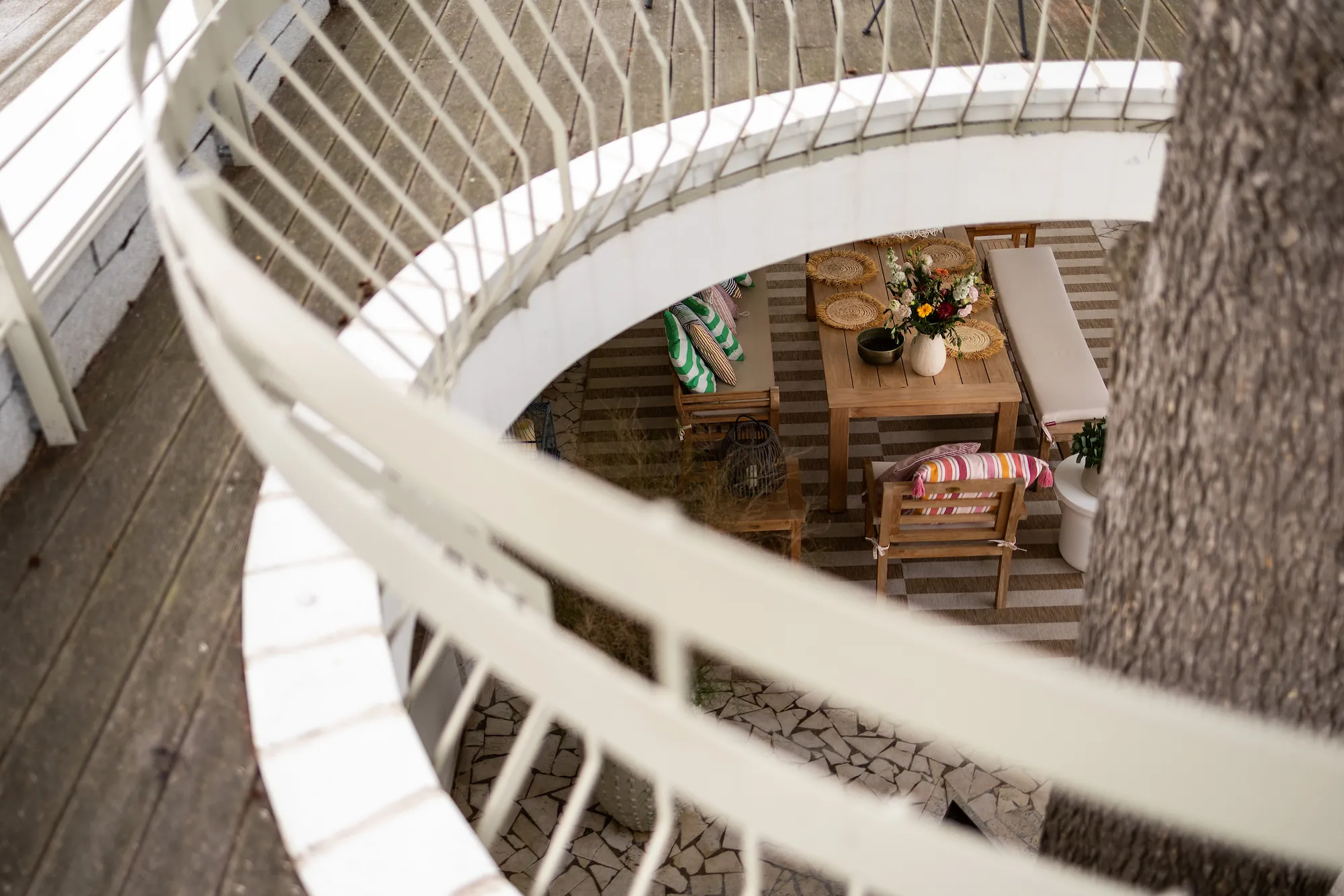 Looking down through the curved white railing of the circular opening to the terrace below