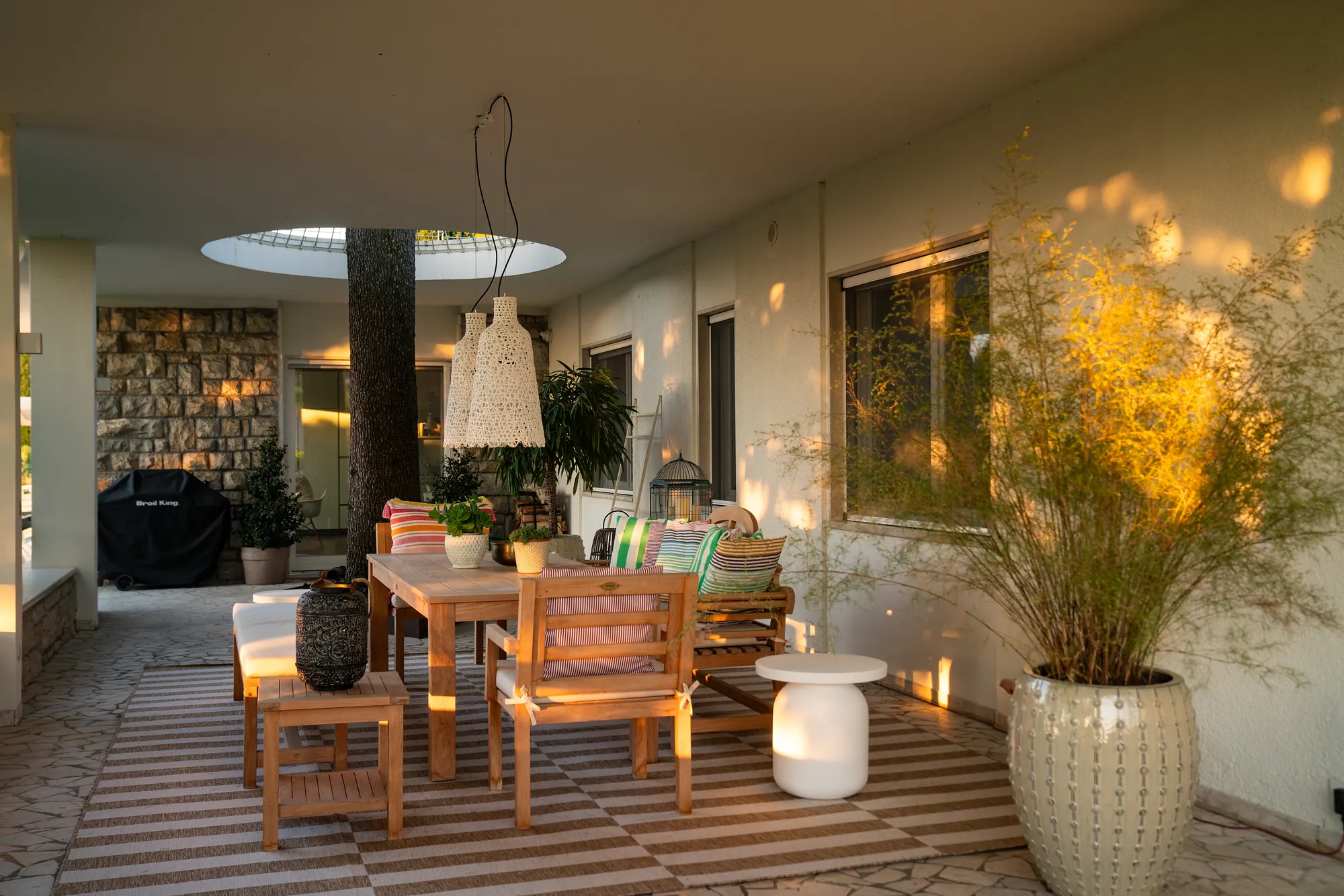 Evening on the main terrace, the cedar trunk rising through the circular opening above the table